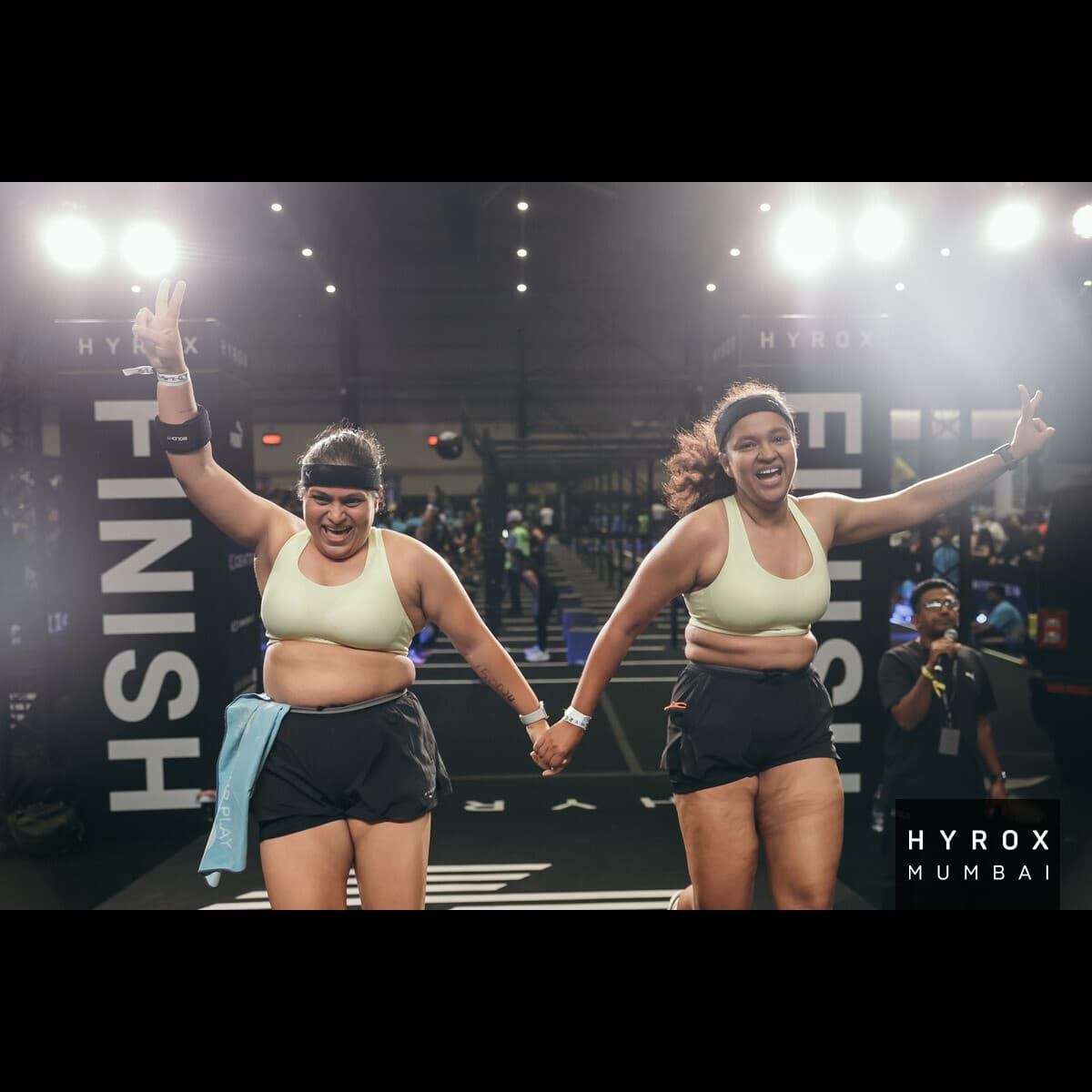 Shubhangini and Kakul celebrating at the HYROX Mumbai 2025 women's doubles finish line
