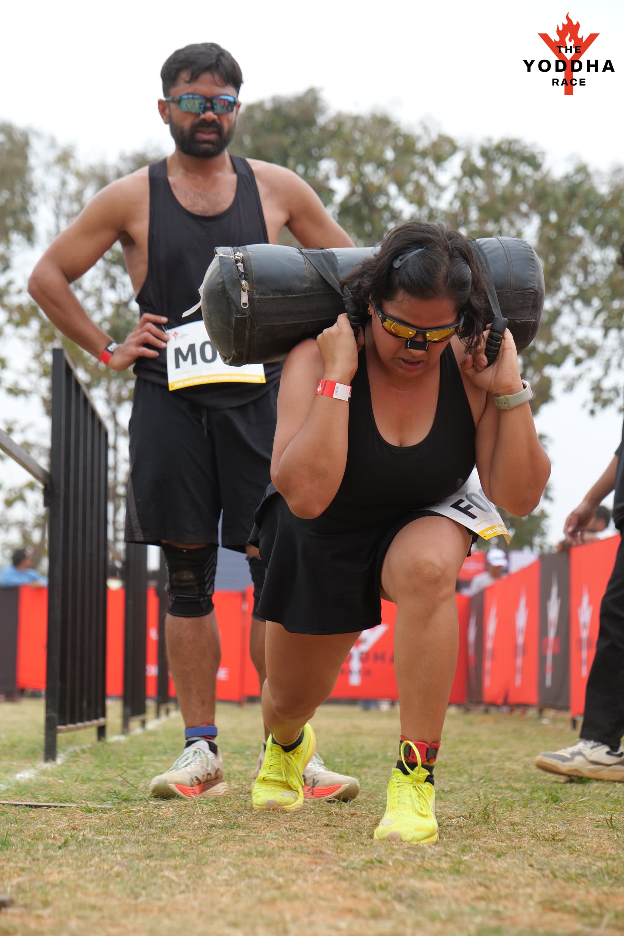 Shubhangini lunging with the sandbag at Yoddha Mixed Doubles while Naman waits for the handoff